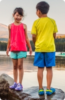 2 kids standing near water.